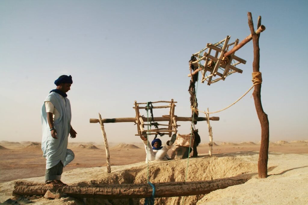 pexels-photo-17399217 Nomads extracting water from a traditional well in the Moroccan desert under the warm sun.