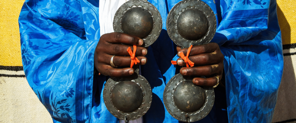 a gnawi musicien playing with his "QarQabat"